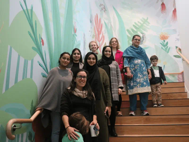 Group photo of Ready Steady Prep participants on stairway with mural of plants