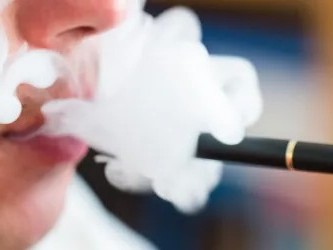 A mouth blowing out a vape cloud.