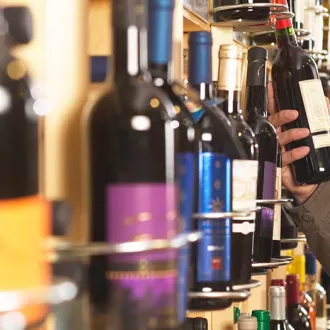 Mean selecting wine from a store