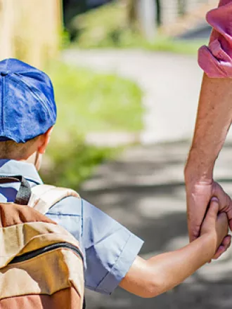 A photo of a school child holding hands with a parent