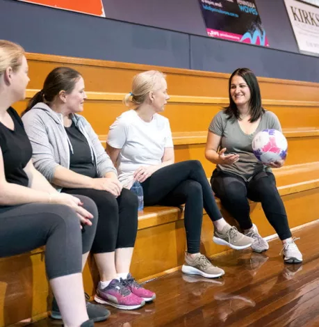 Kelly and others at a indoor basketball and netball court.