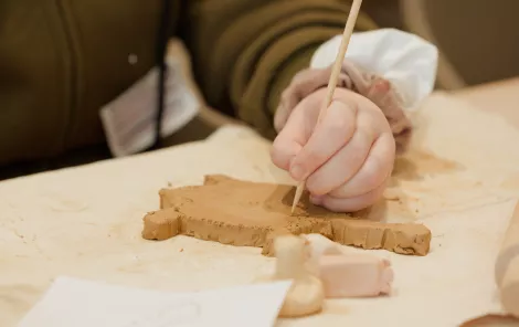 A close up of a young person making a turtle out of clay