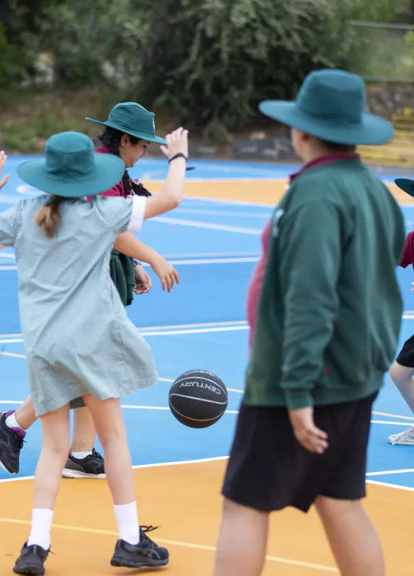 A photo of school children playing basketball