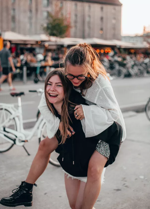 A photo of a young person piggybacking her friend